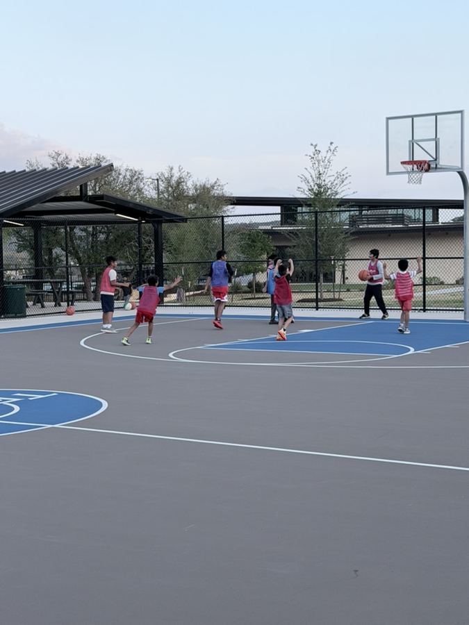 Kids playing near the hoop at sunset
