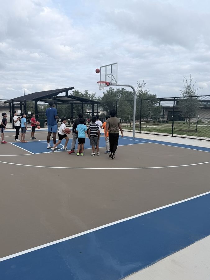 Group of kids and a coach on the court
