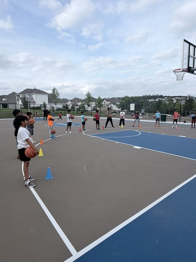 Kids lined up with basketballs during a drill